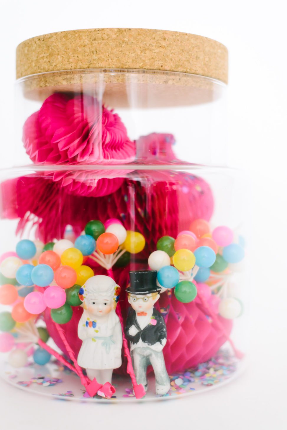 wedding party terrarium with pink and yellow mini pinatas and little people