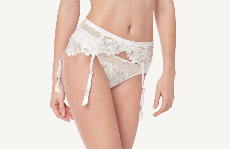 Close up of woman wearing white floral waist garter and underwear