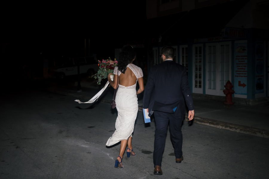 Bride and groom walking into the night