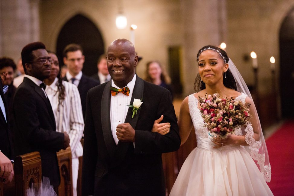 bride walking down church aisle with father
