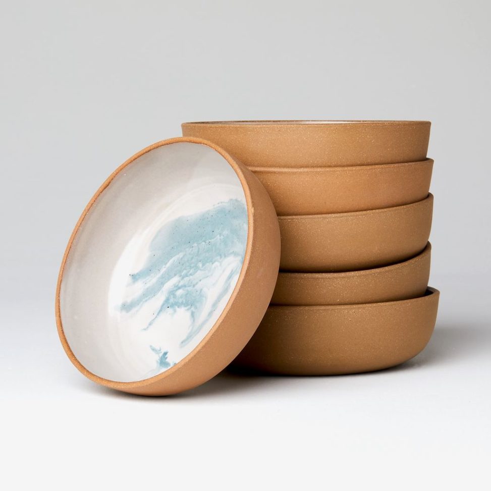 Stack of ceramic bowls with brown exteriors and blue and white marbled interiors