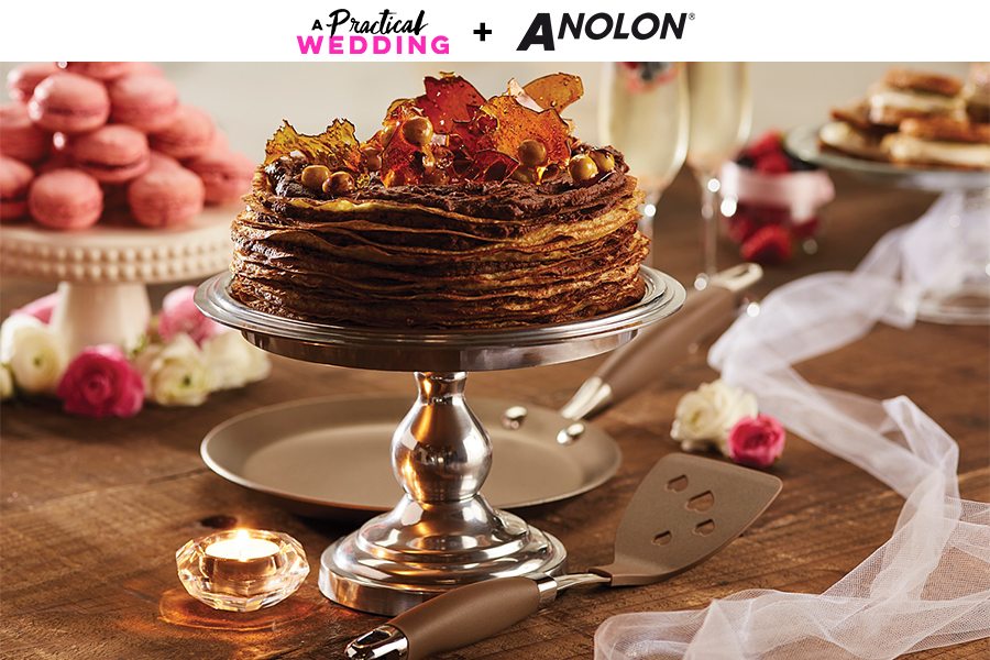 Dessert tablescape with chocolate layer cake on a cake stand with macrons and champagne flutes and whoppie pies in the background. Banner reads A Practical Wedding + Anolon.