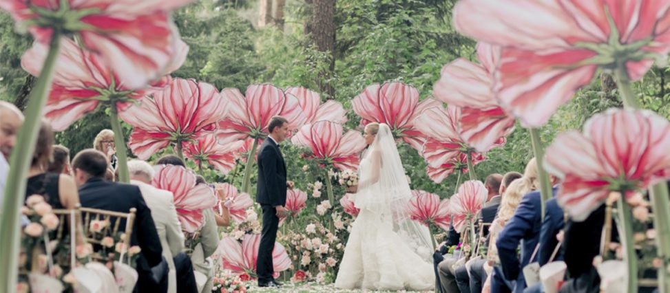 couple standing among large artificial flowers
