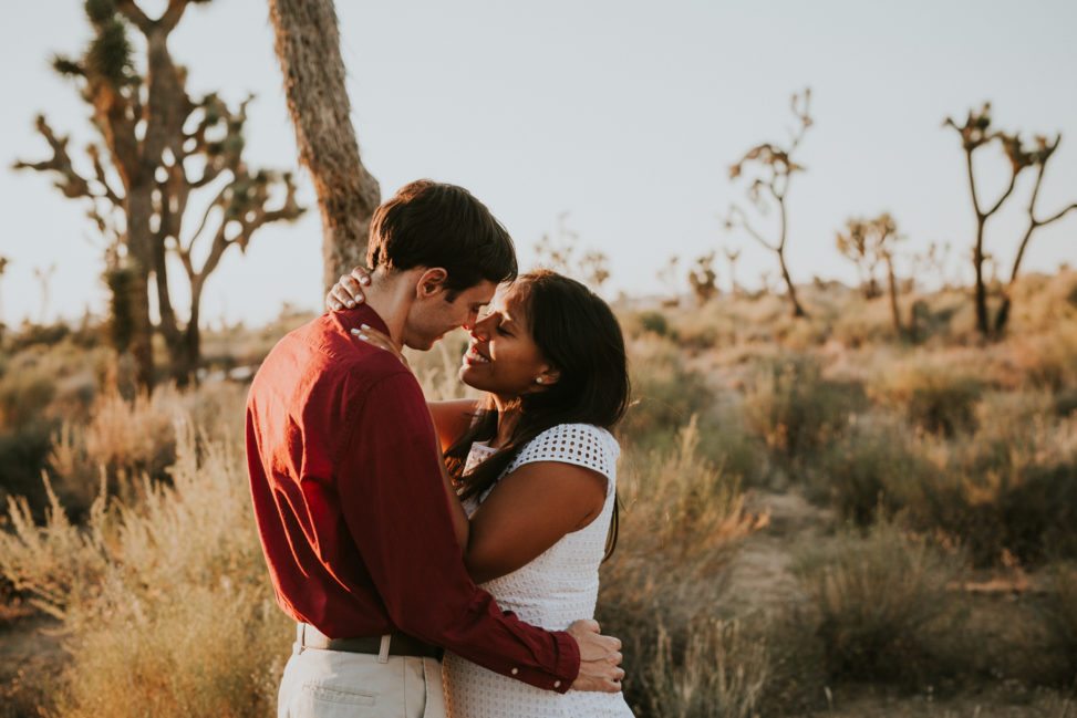 bride and groom in red shirt embracing in Joshua Tree desert