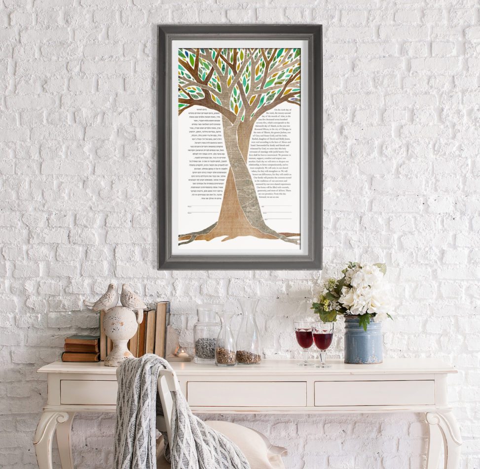 a ketubah featuring an illustration of intertwined trees hanging on a wall above a desk