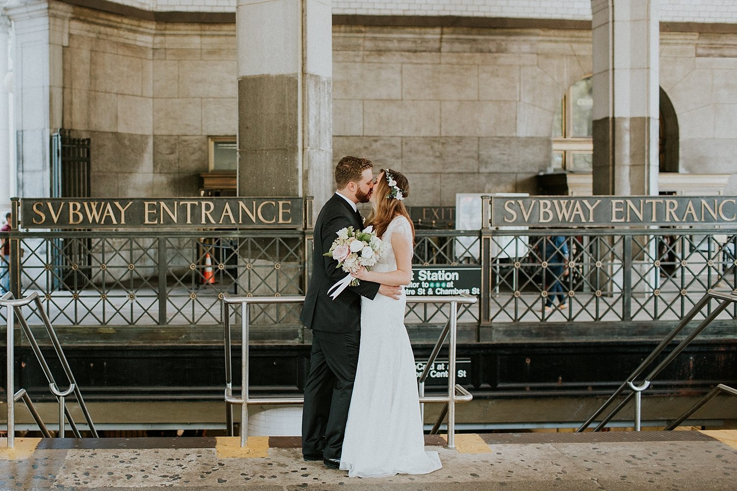 bride and groom kissing at a subway entrance