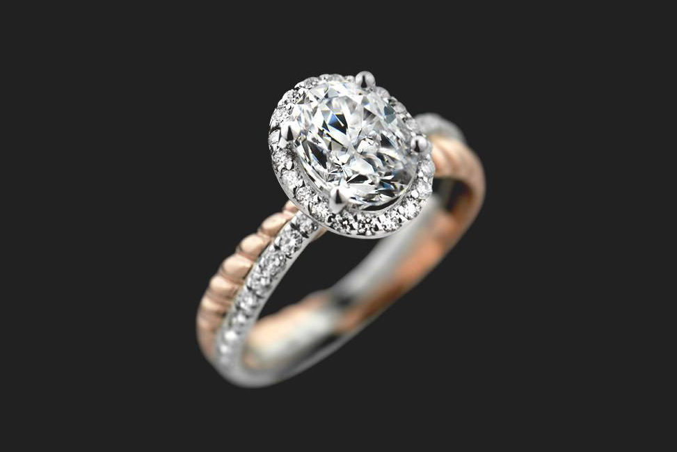oval shaped two tone ethical diamond engagement ring with halo setting and rope style band