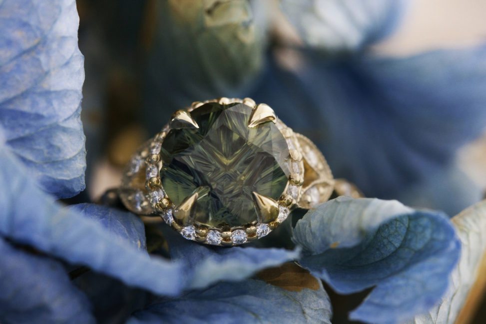 An amazing emerald engagement ring set on blue leaves