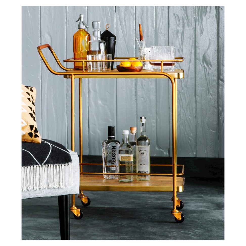 metal, wood and leather bar cart next to chair in elegant room