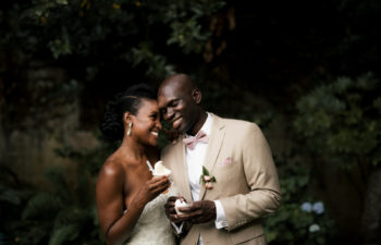 Couple in wedding clothes smiling at each other and eating ice cream
