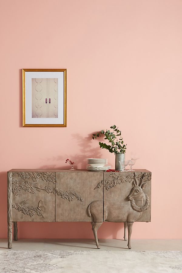 Carved buffet with deer image in a pink room