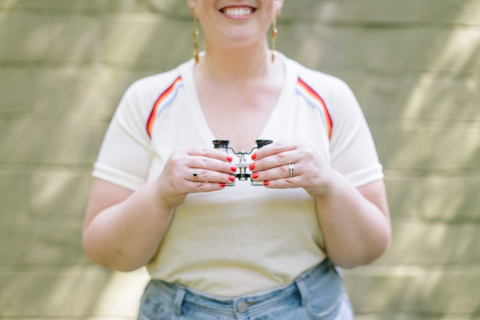 woman with red nails holding binoculars 