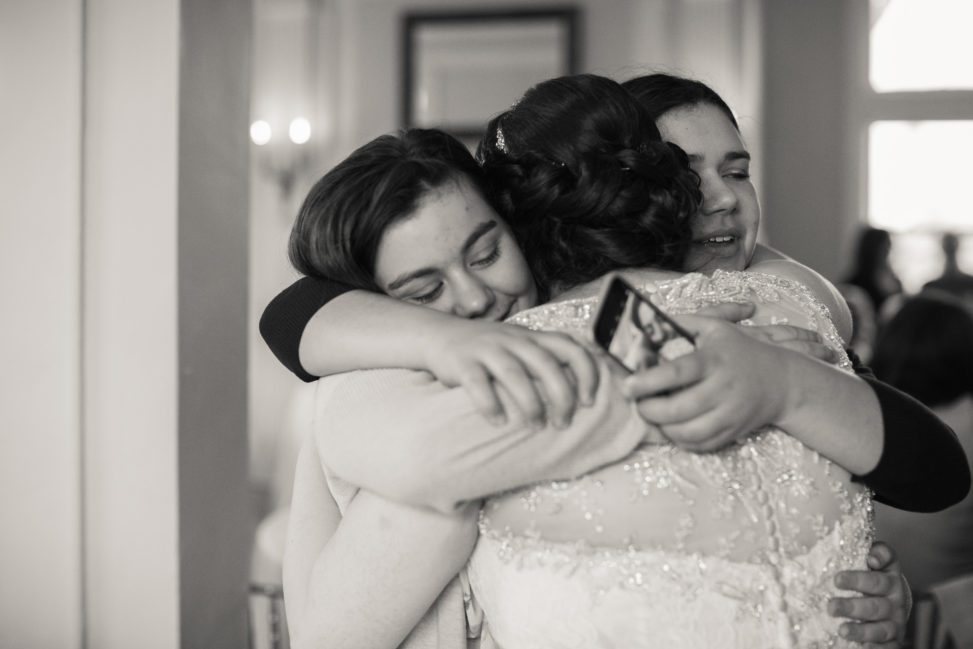 black and white image of bride hugging two other women