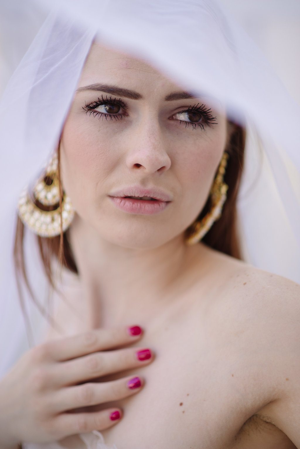 A woman looks on through a wedding veil