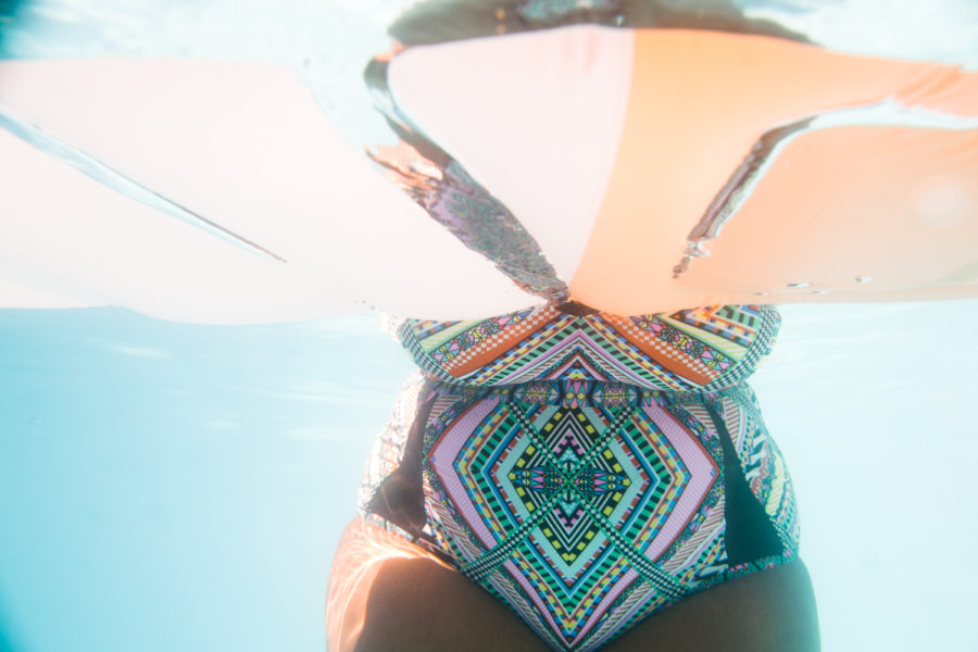 torso of a woman in a colorful swimsuit, under water