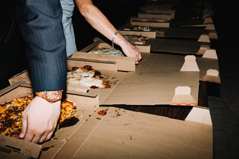 a row of pizzas in boxes during a wedding reception