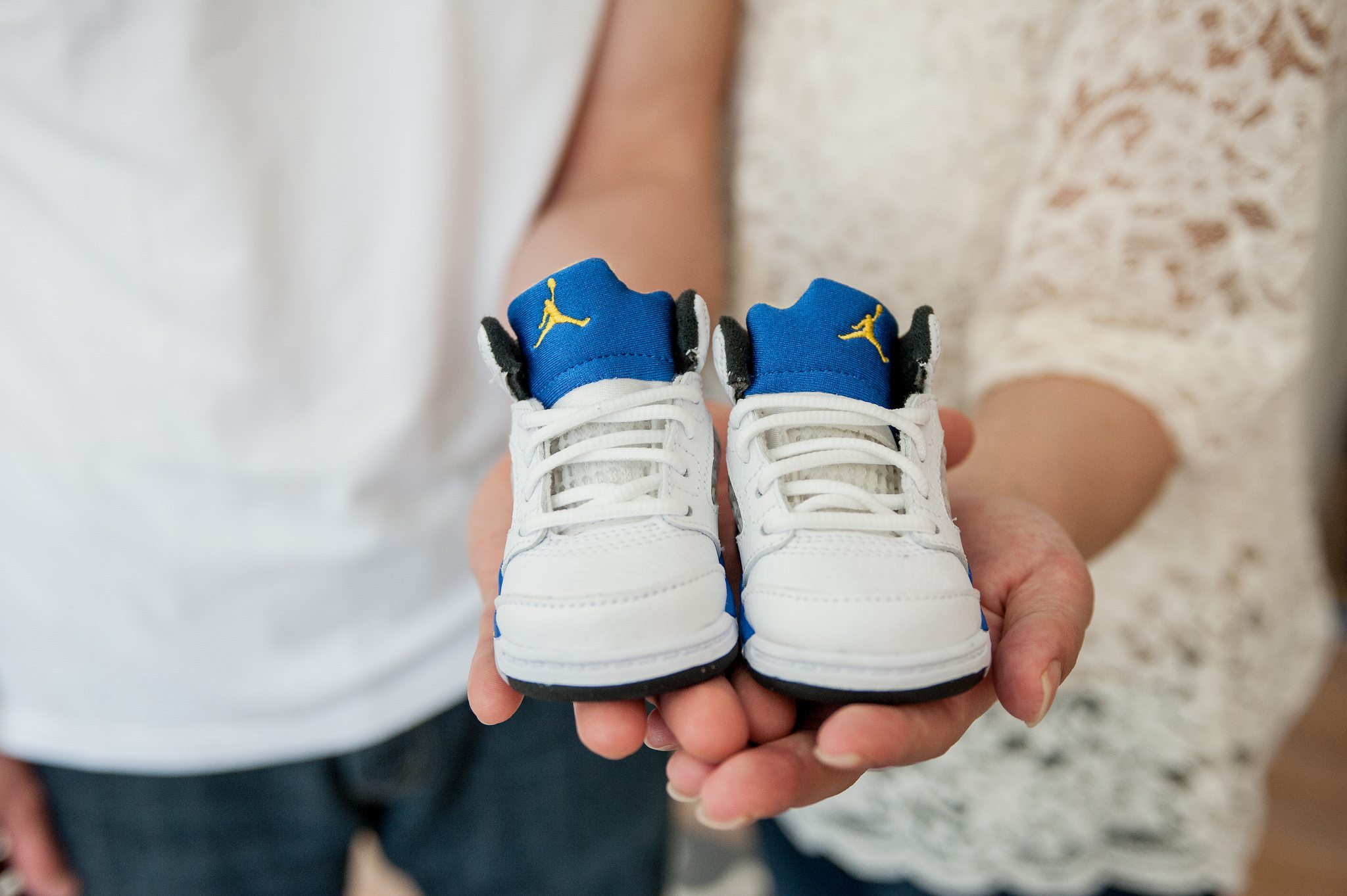 A couple hold a pair of baby shoes