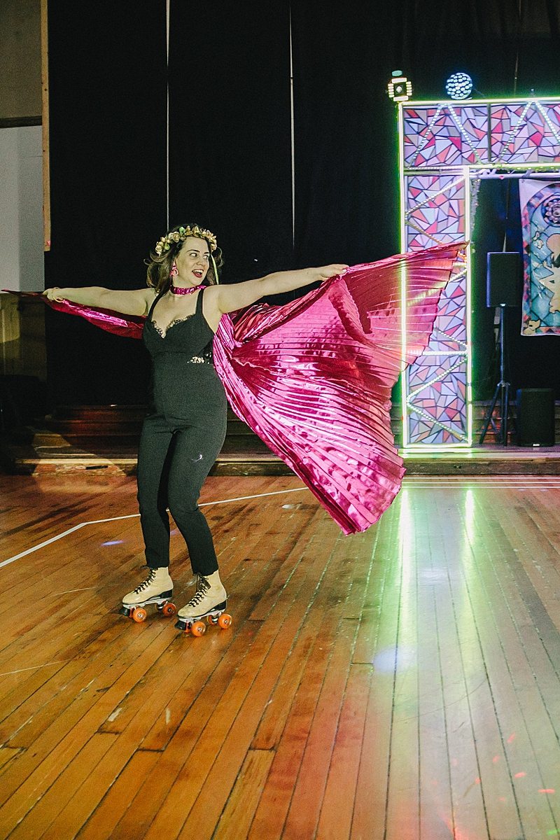 a woman continues to float through the world with a large cape, on skates