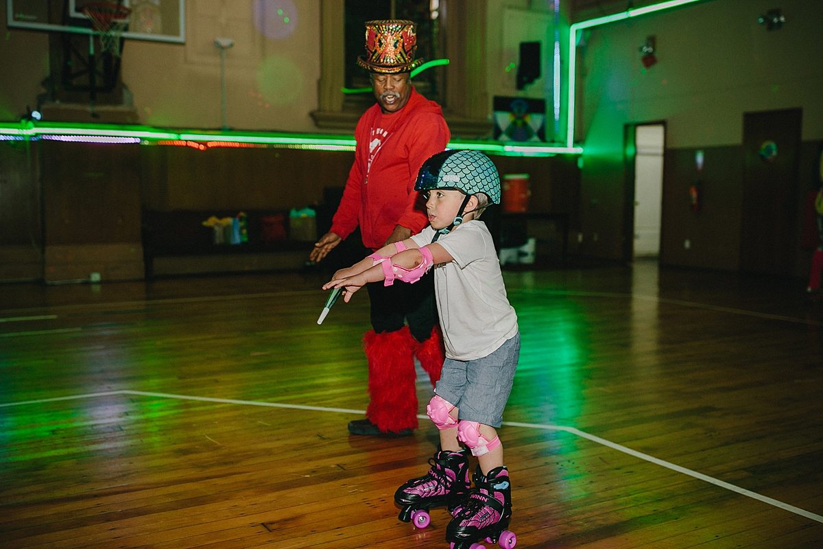 an older gentleman roller skates with a young child
