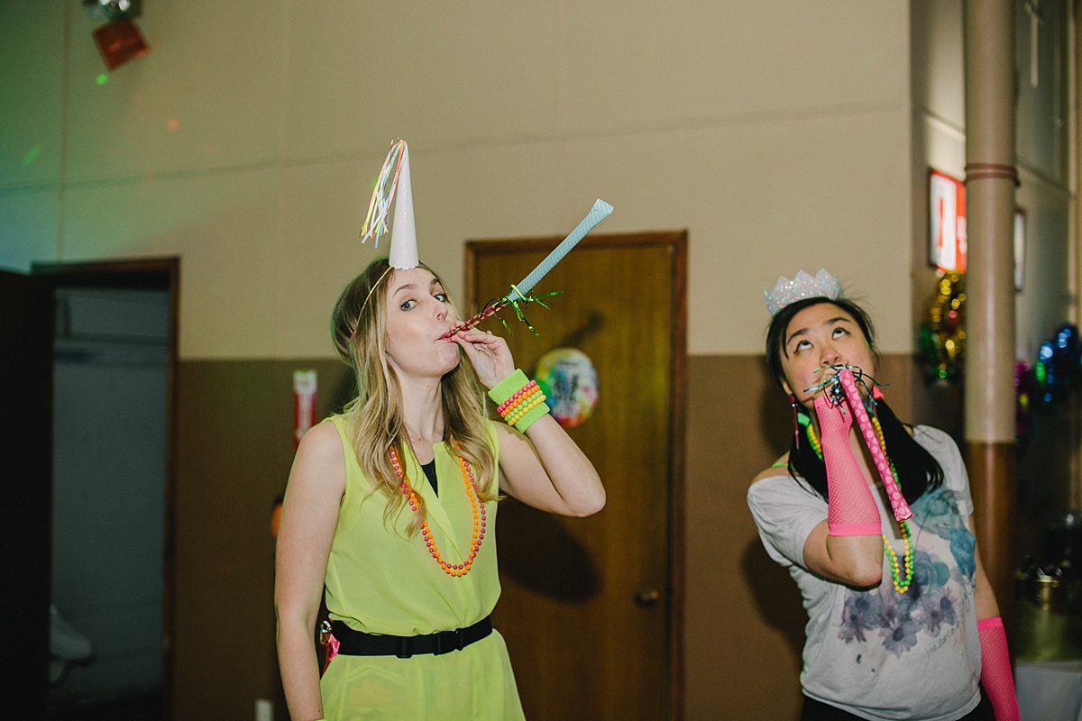 two women blow party blowers