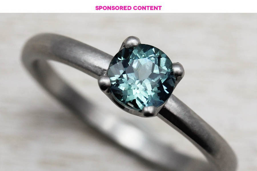 blue-green gem set on silver ring with sponsored content written above