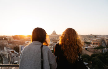 two woman looking at view with golden sun shining down