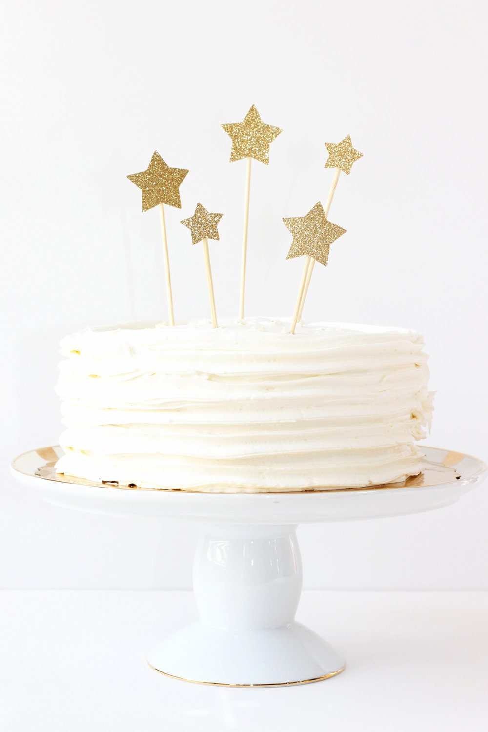 sparkly golden stars wedding cake topper on white cake