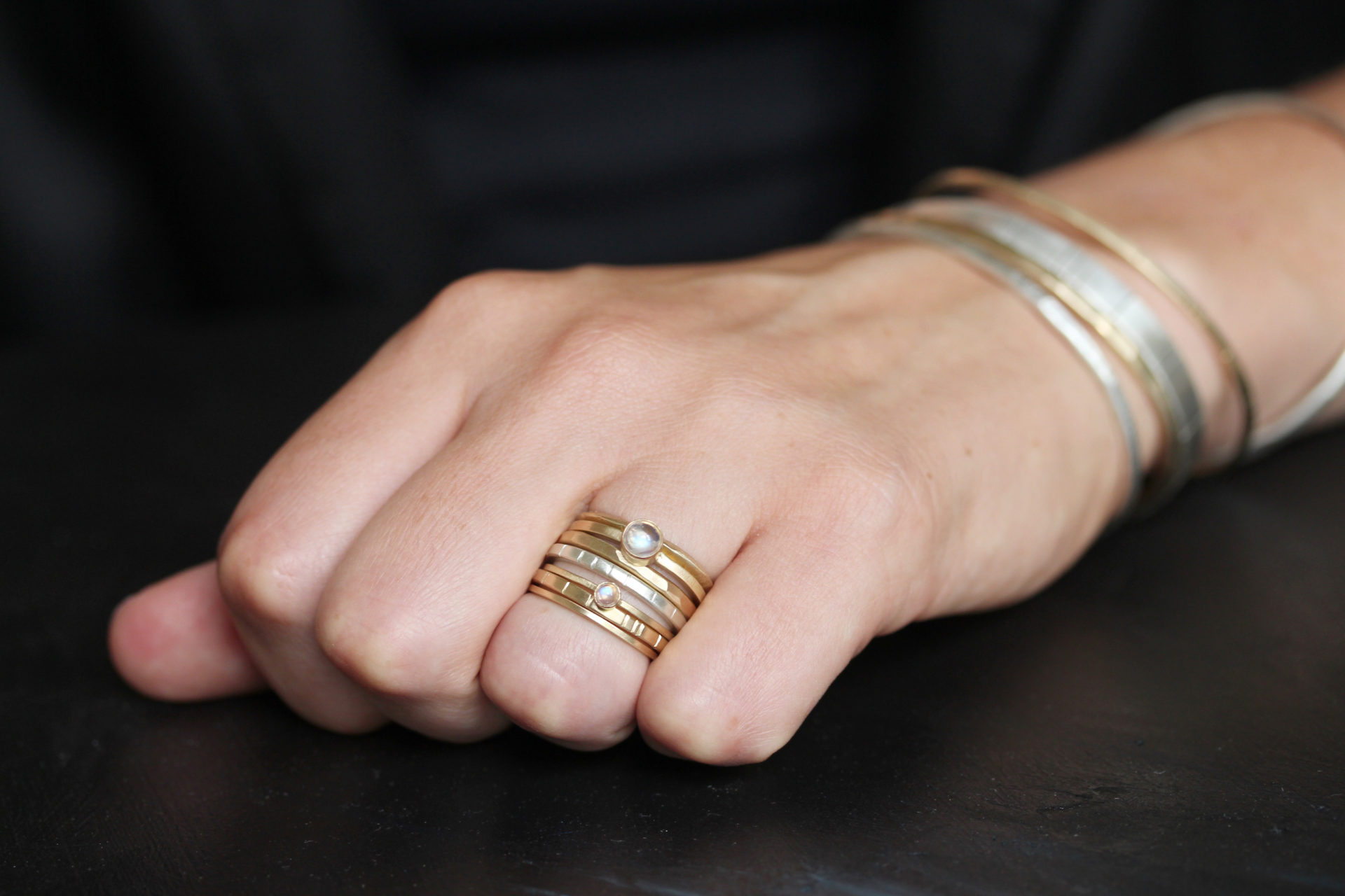 photo of a closed hand with rings and bangle bracelets