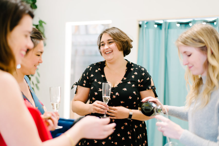 Women smiling and toasting with champagne in a design studio