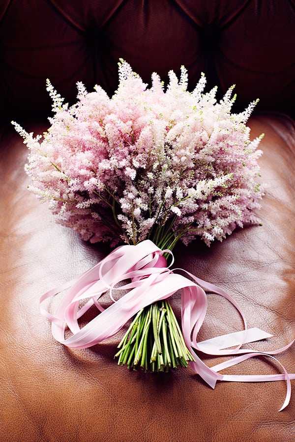 hand-tied pink bridal bouquet on leather couch