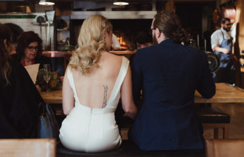 A man and woman sit at a bar