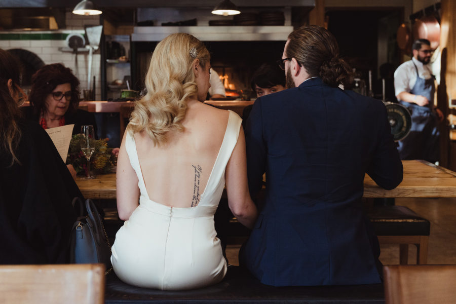 A man and woman sit at a bar