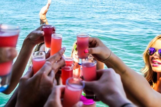 A group of people on a boat raise their glasses in a toast
