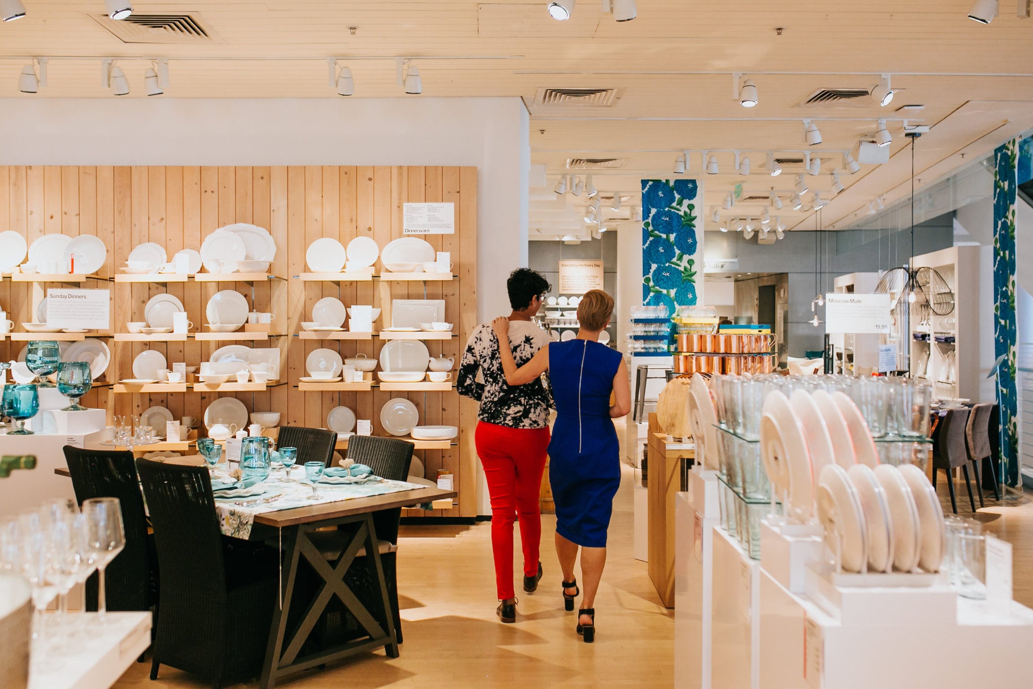 two women embracing while walking through a crate and barrel LGBTQ private registry event