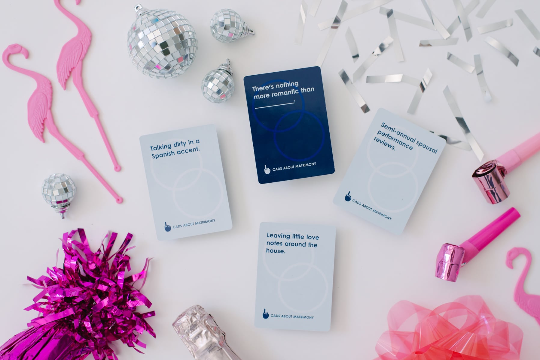 a bachelorette party card game surrounded by pink party supplies