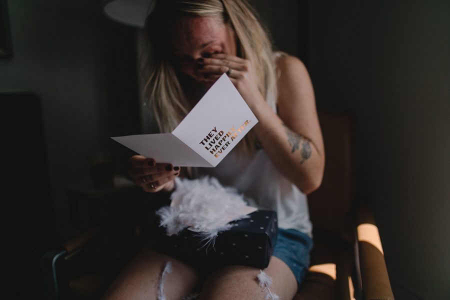 A woman reads a card, and cries