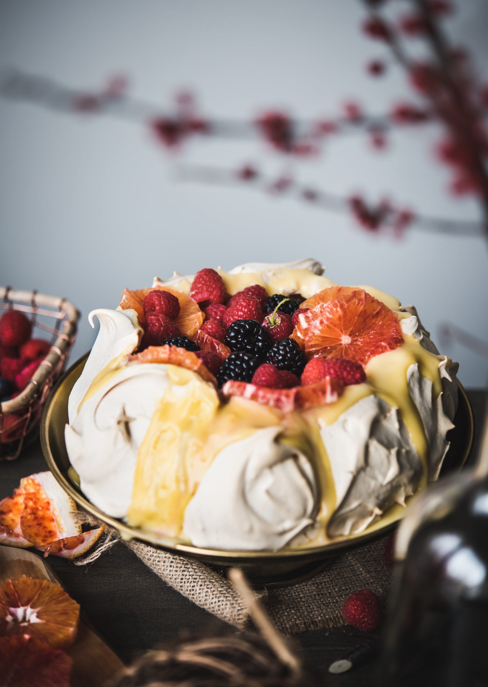 pavlova on table topped with berries and lemon curd