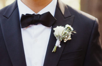 Closeup of a man's bow tie and boutonnière