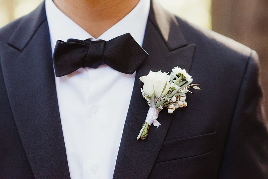 Closeup of a man's bow tie and boutonnière