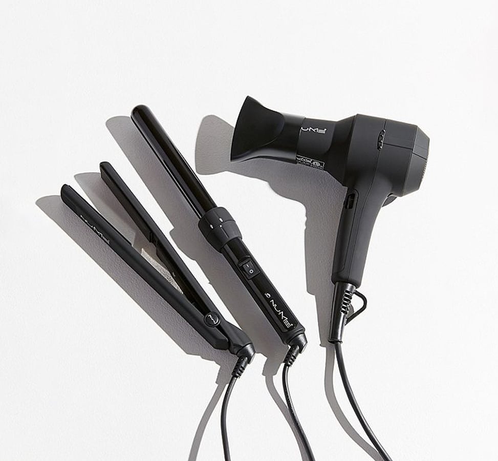 a black flat iron, curling wand, and hair dryer.
