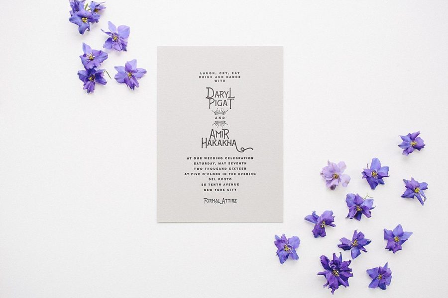 black and white letterpress invite surrounded by purple flowers
