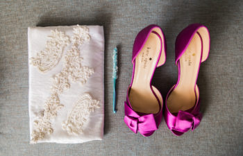 magenta satin slides and a while lace appliqué clutch