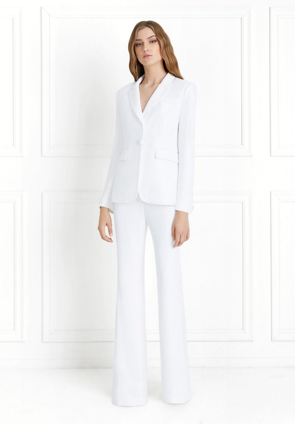 A woman wears a white pantsuit