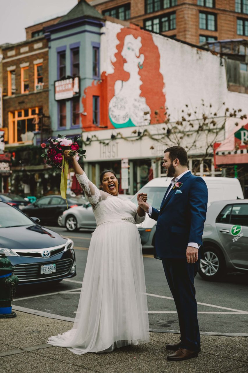 A couple in wedding clothes is joyfully exuberant on the streets of DC. Rachel Couch for Pop! Wed Co.