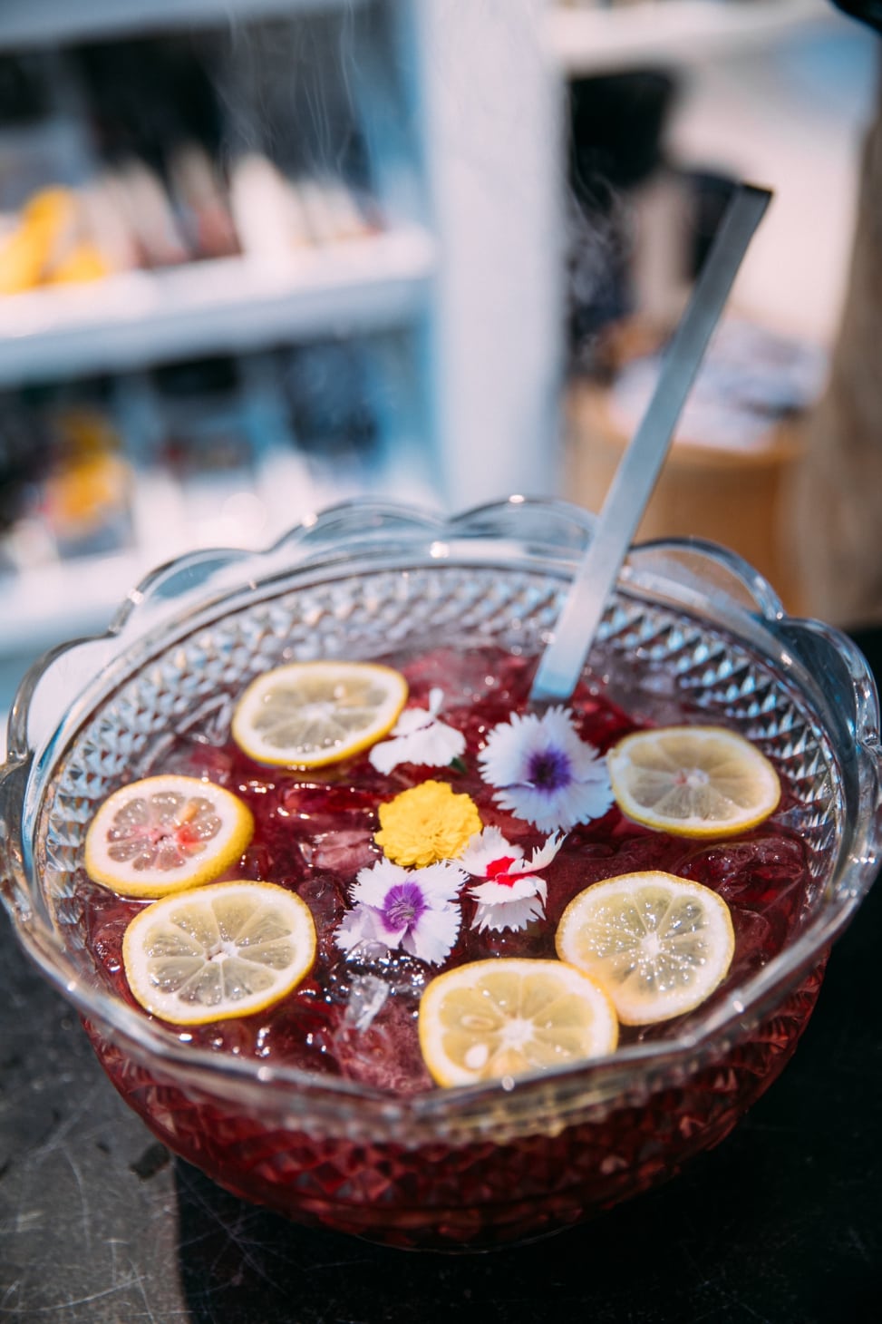 Punch bowl filled with punch, lemon slices, and flowers at the crate and barrel san francisco private registry event with a practical wedding
