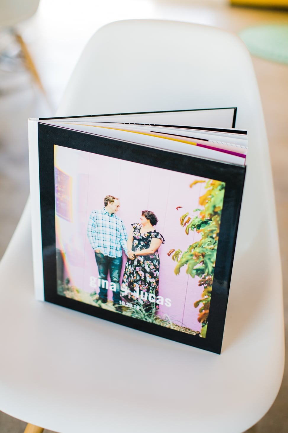 a personalized guest book with an image of a couple holding hands and smiling on the cover with the text "gina + lucas" overlaid