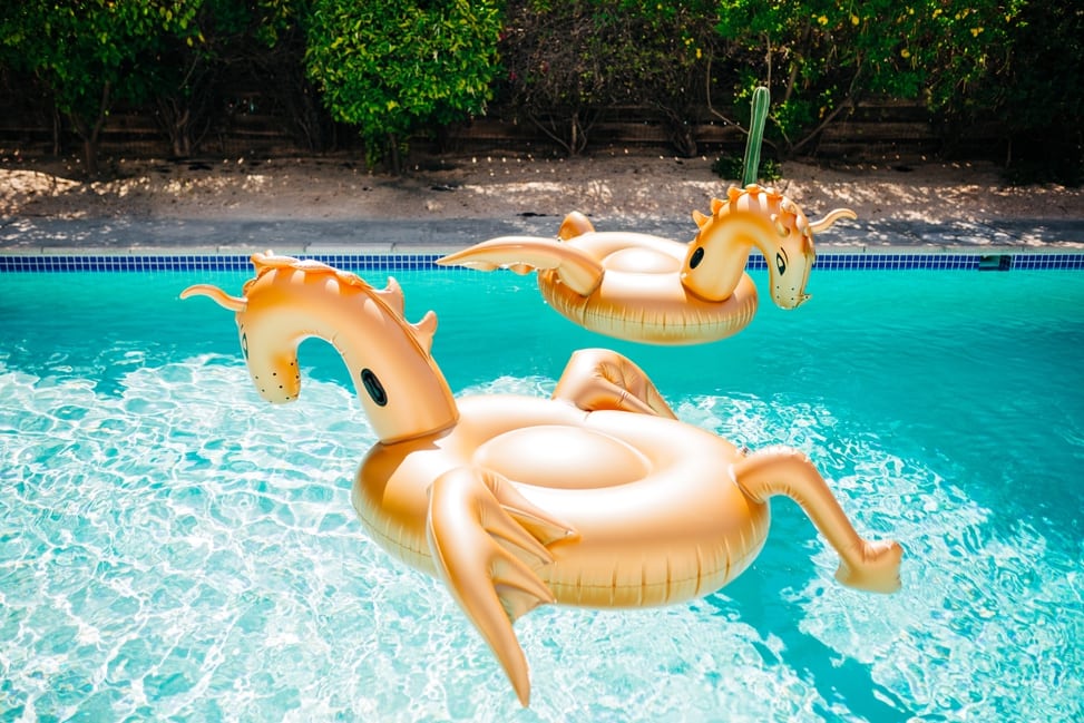 two gold inflatable dragon rafts float in a pool