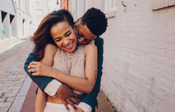 a couple embracing and smiling in an alleyway