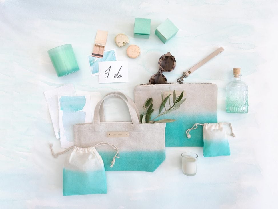 a collection seafoam green items from minted, included dip-dyed bags, an ombre deco bottle, and a votive candle in a glass holder