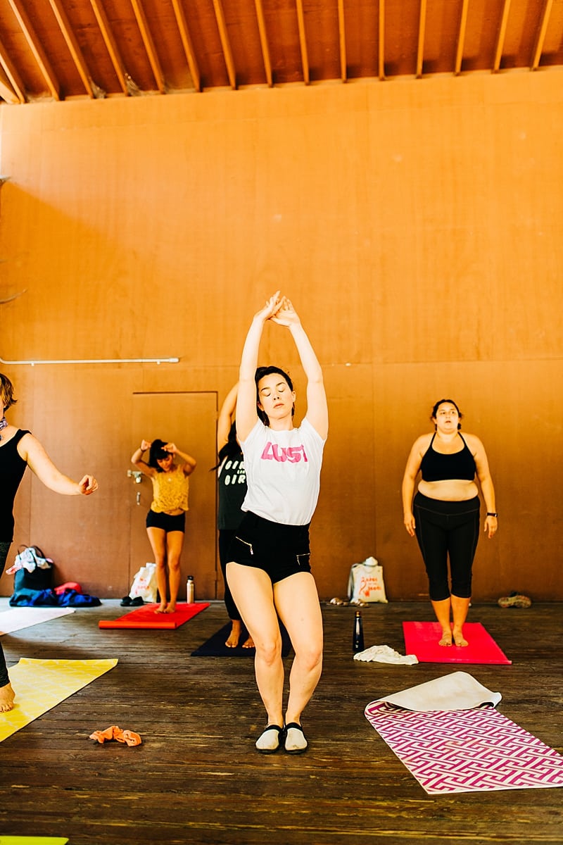 Women doing yoga during Chloe Jackman's workshop at the compact summer camp in la Honda, CA